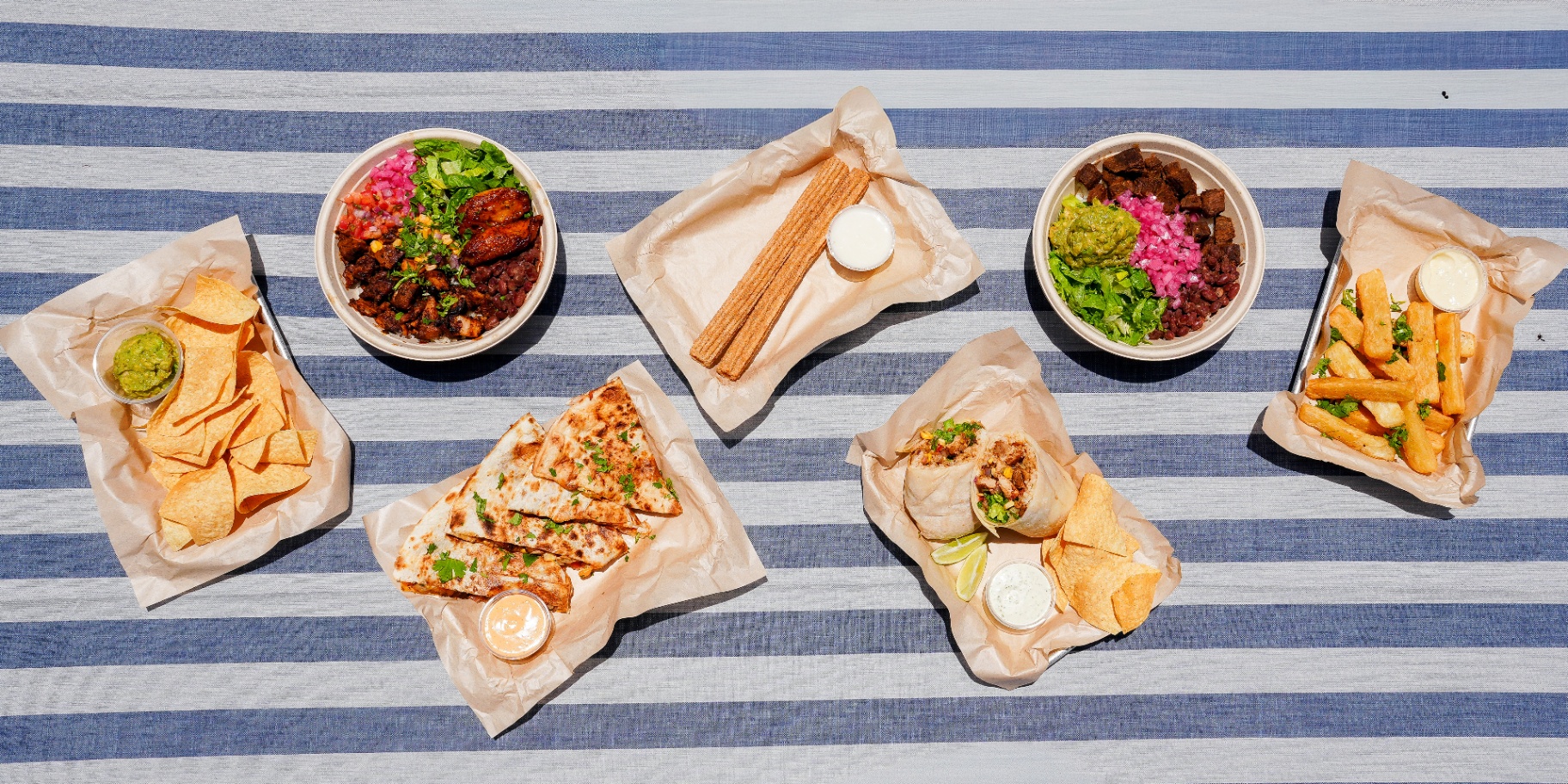 Tela Latin Grill food spread featuring bowls, quesadillas, churros, and more